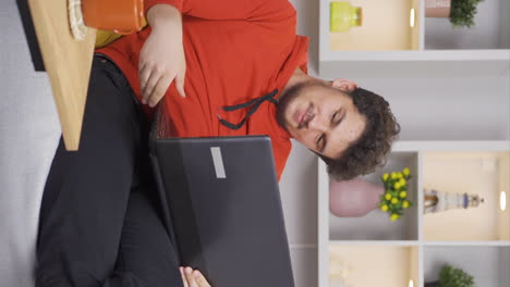 Vertical-video-of-Man-watching-movie-on-laptop-with-happy-expression.